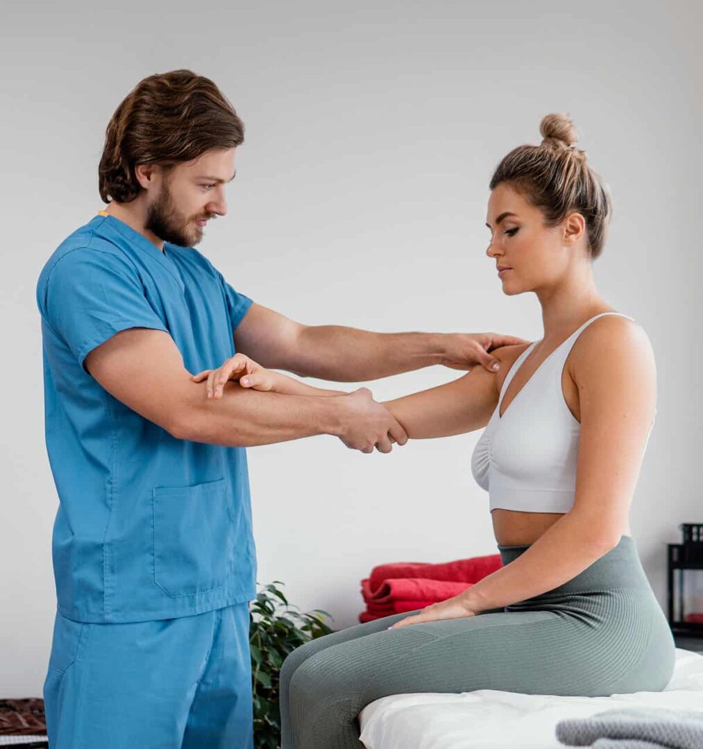 co zyskujesz wybierając fizjoPS - fizjoterapeuta masuję rękę pacjentki siedzącej na leżance