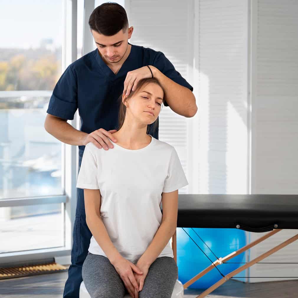 korzyści fizjoterapii bólu, urazów, po operacji - fizjoterapeuta masuje kark pacjentki